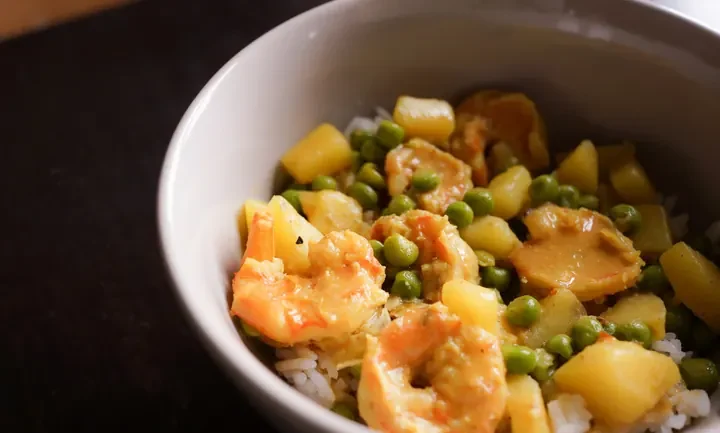 Photographie : Crevettes au curry avec pommes de terre et petits pois